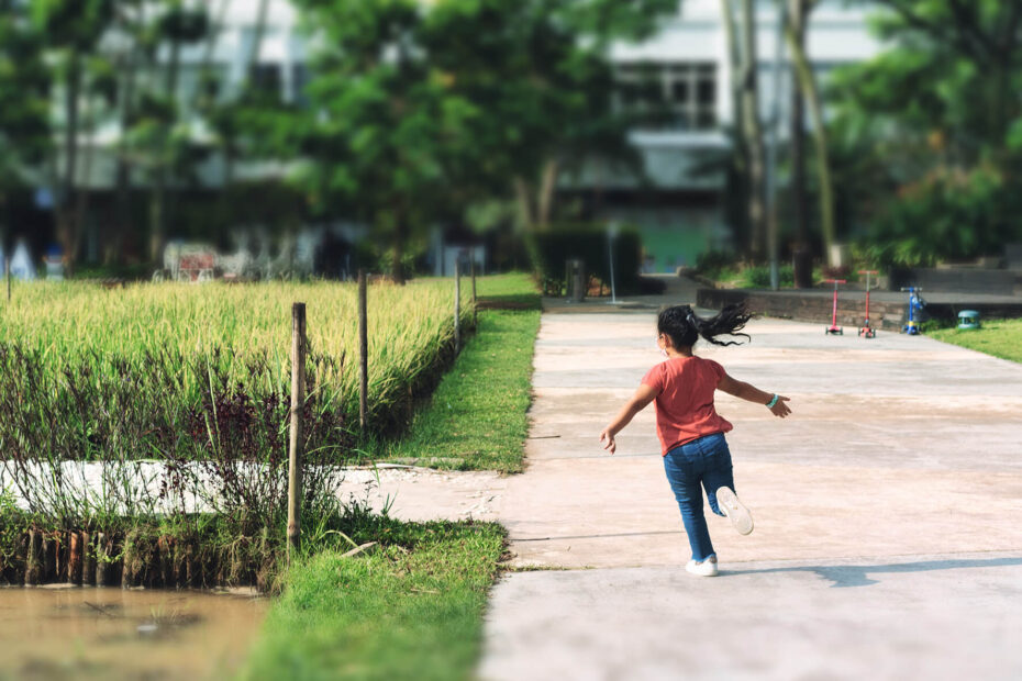 Back view of young girl running in the park