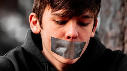 Young boy with duct tape over his mouth